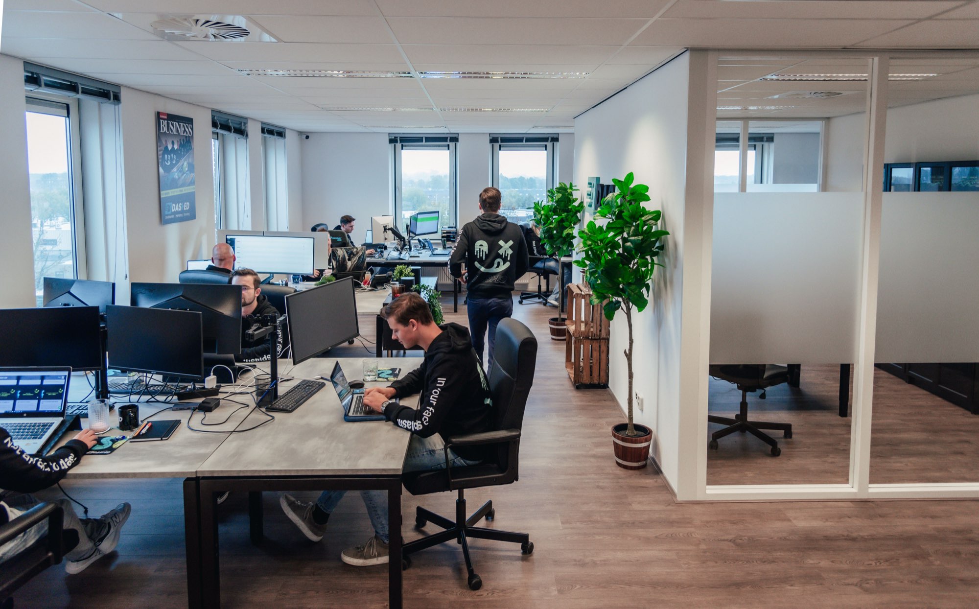 Medewerkers aan het werk in de kantoortuin met planten