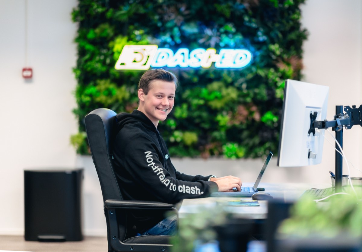 Medewerker aan het werk voor de verlichte Dashed-logowand
