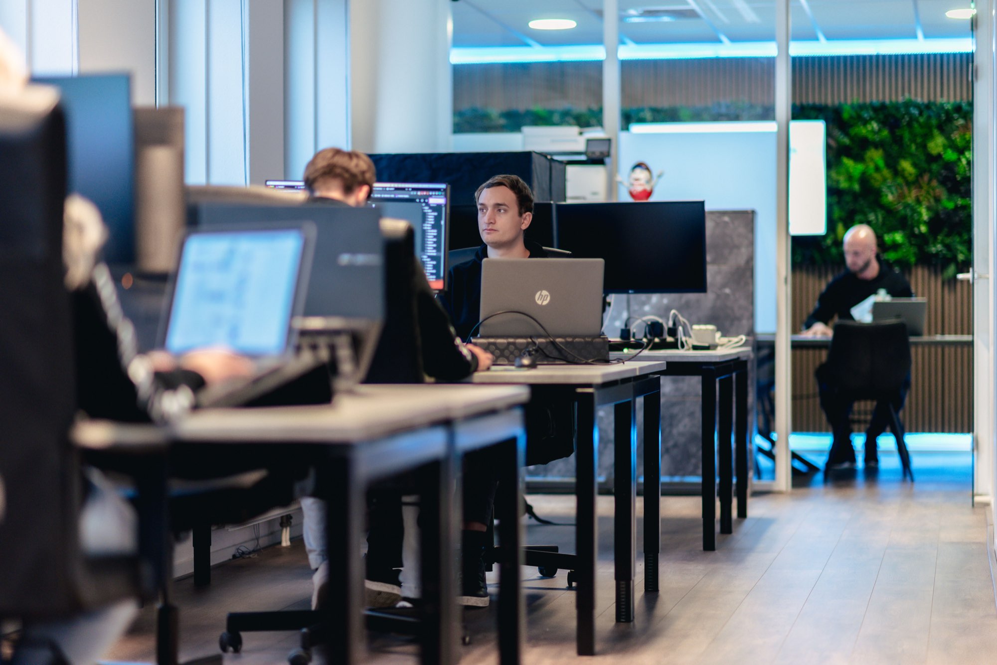 Medewerkers aan het werk achter hun bureau in de kantoortuin