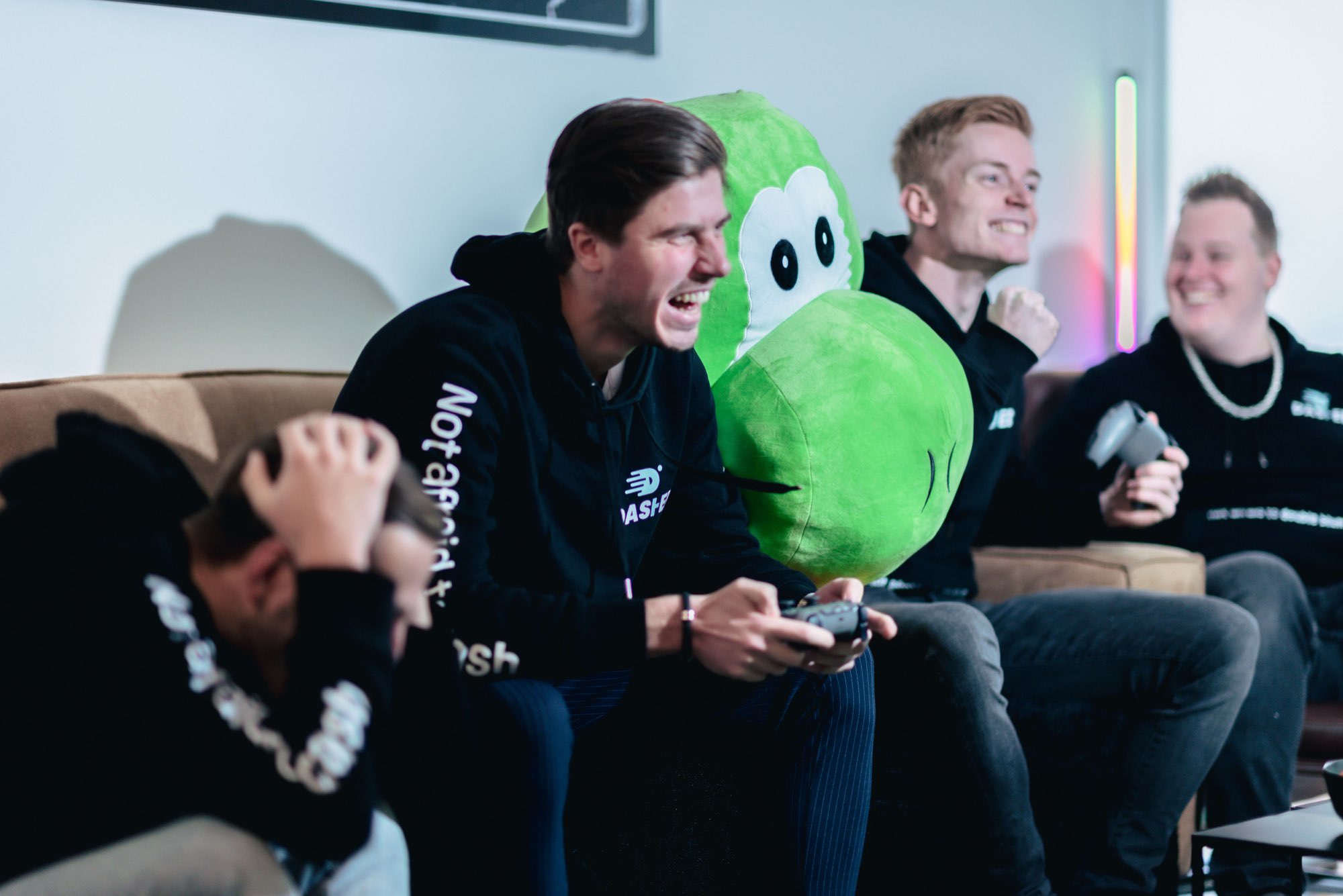 Collega's lachen tijdens het gamen met de groene mascotte