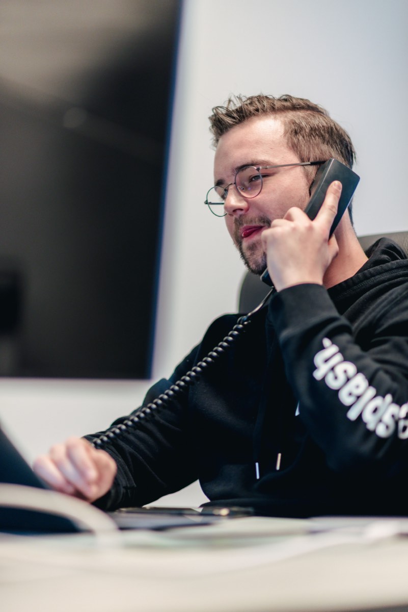 Medewerker aan de telefoon achter zijn monitor
