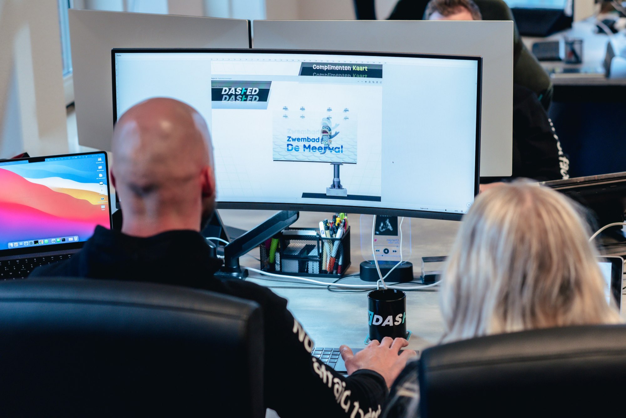 Collega's kijken naar een presentatie op het scherm in de vergaderruimte