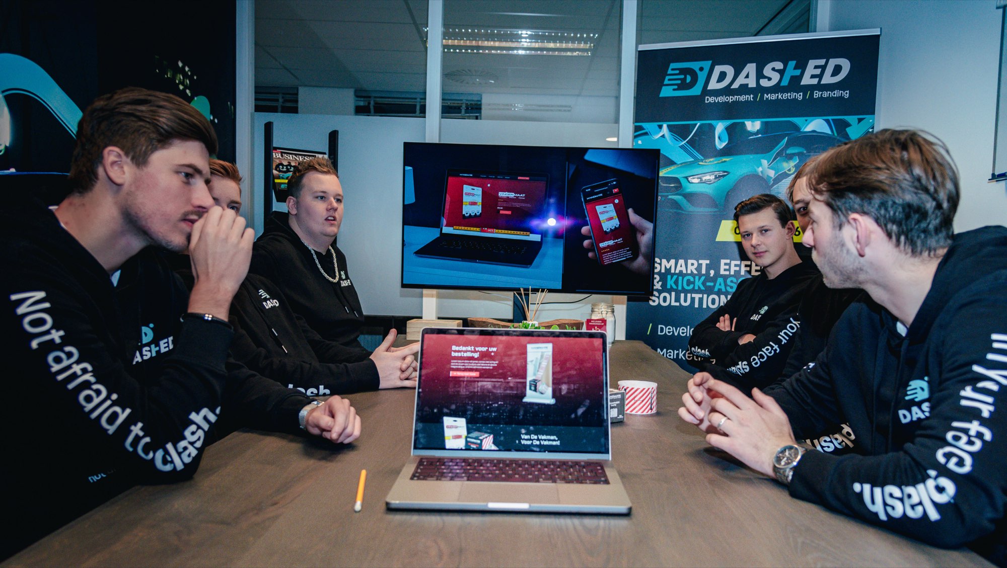 Collega's kijken samen naar een laptop tijdens een werkoverleg