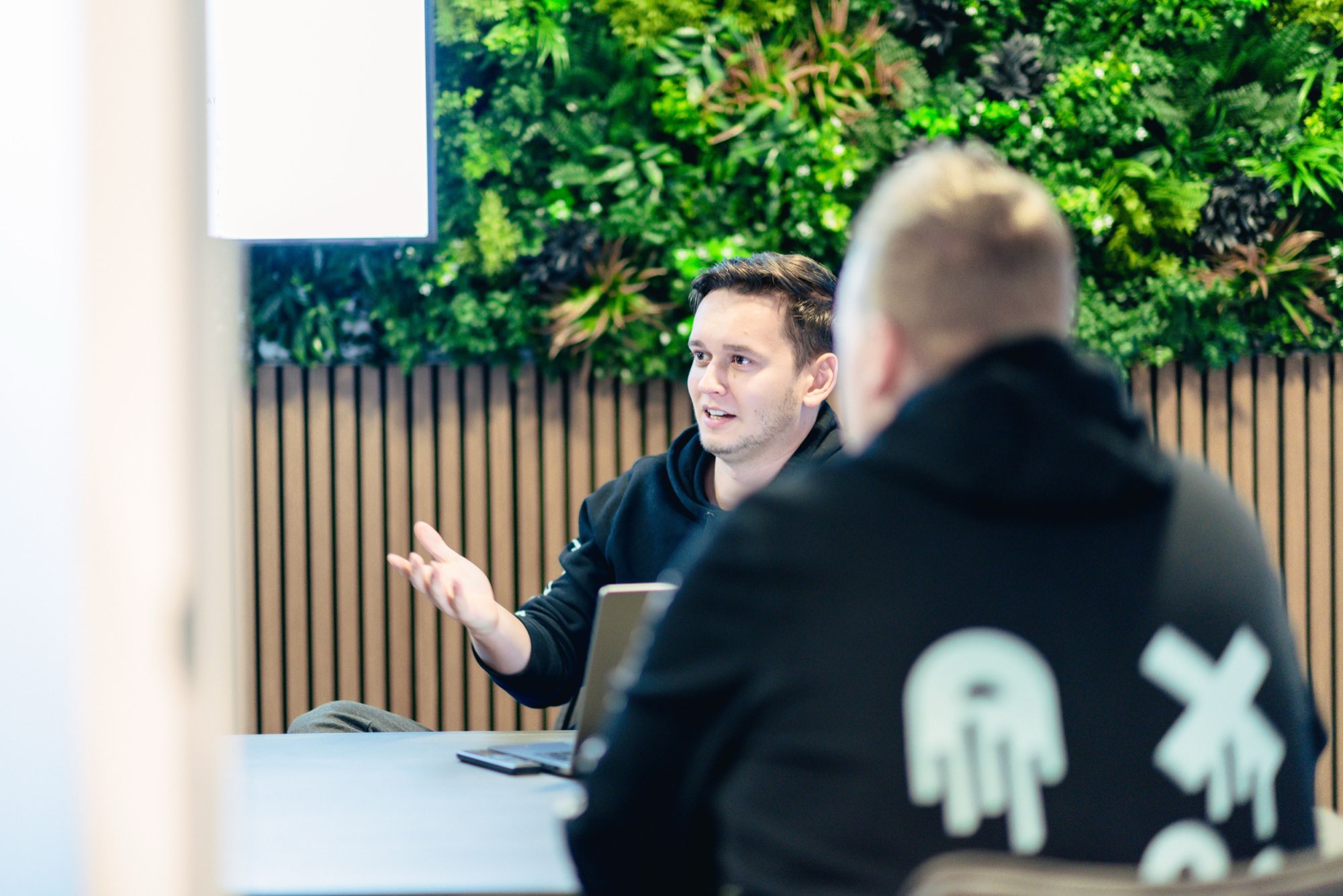 Twee collega's in gesprek voor de groene plantenwand