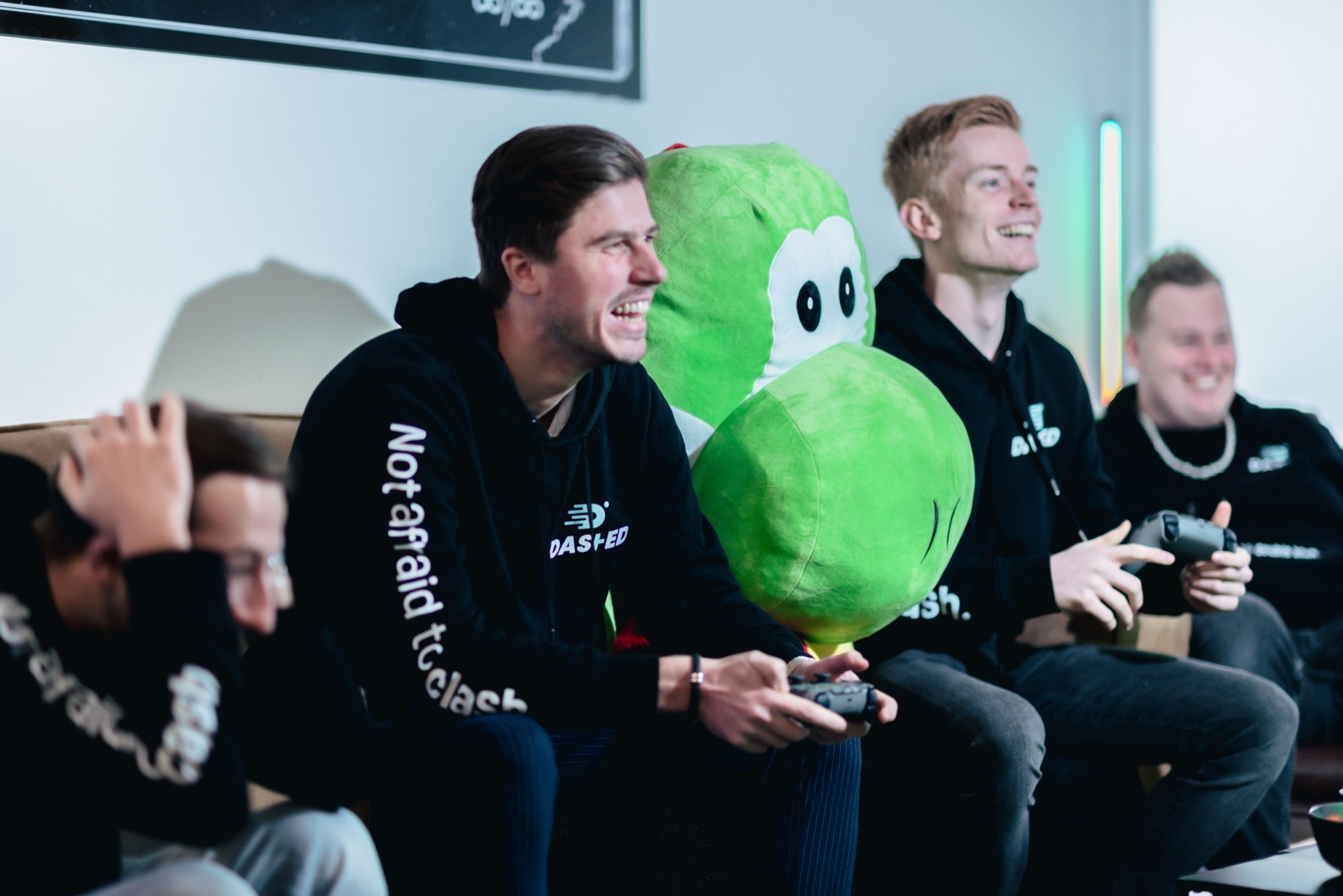 Collega's gamen op de bank met de groene mascotte