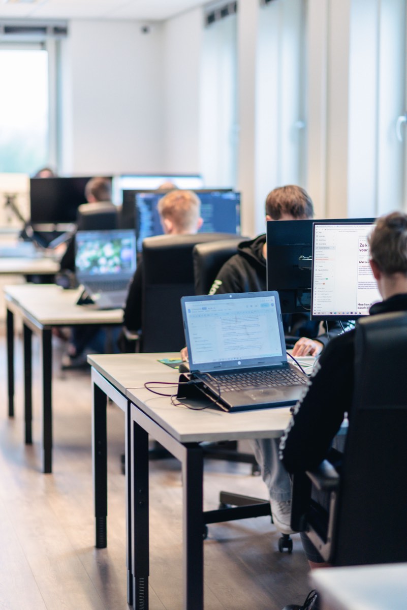 Medewerkers aan het werk aan bureaus bij het raam