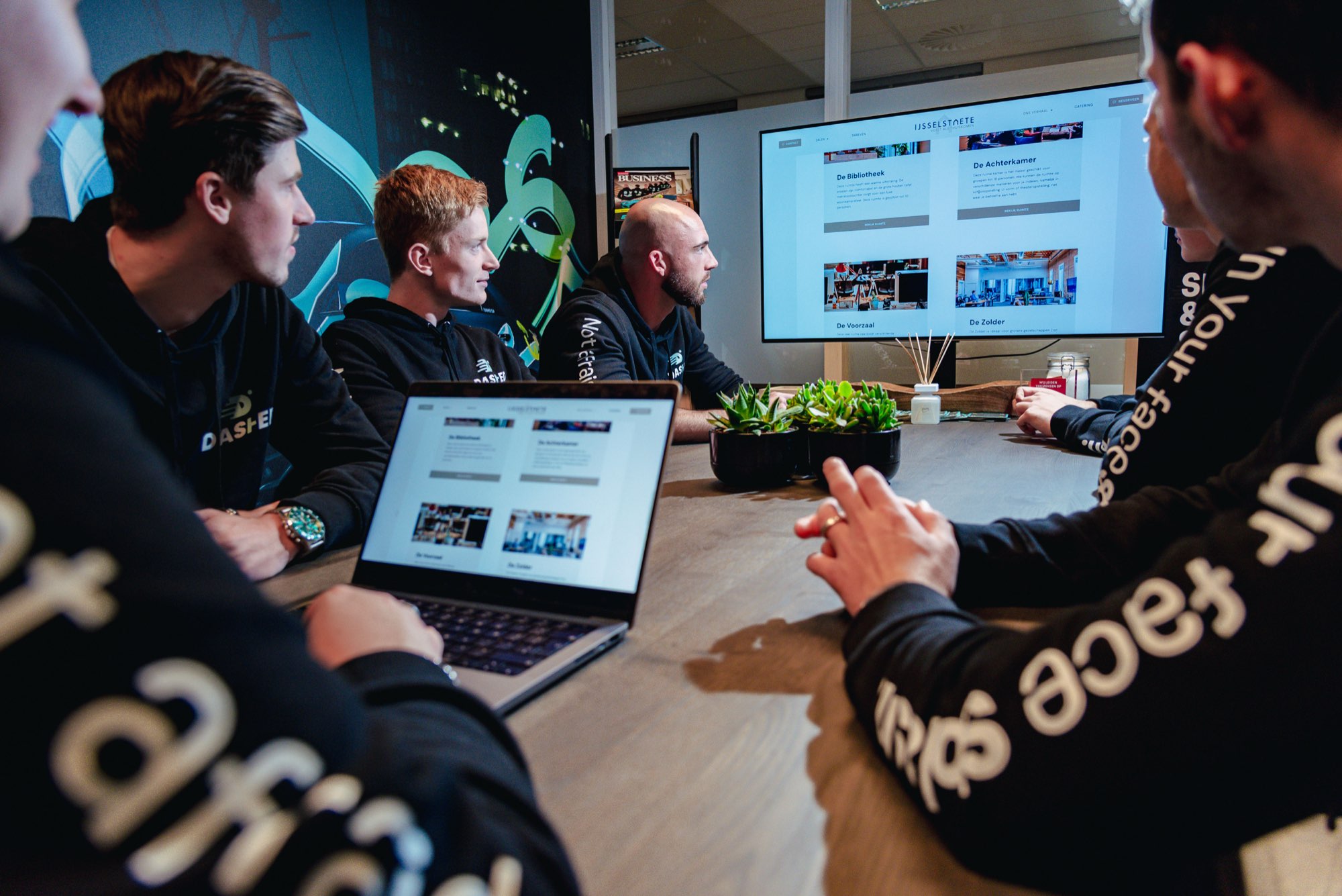 Collega's bekijken samen een website op een laptop
