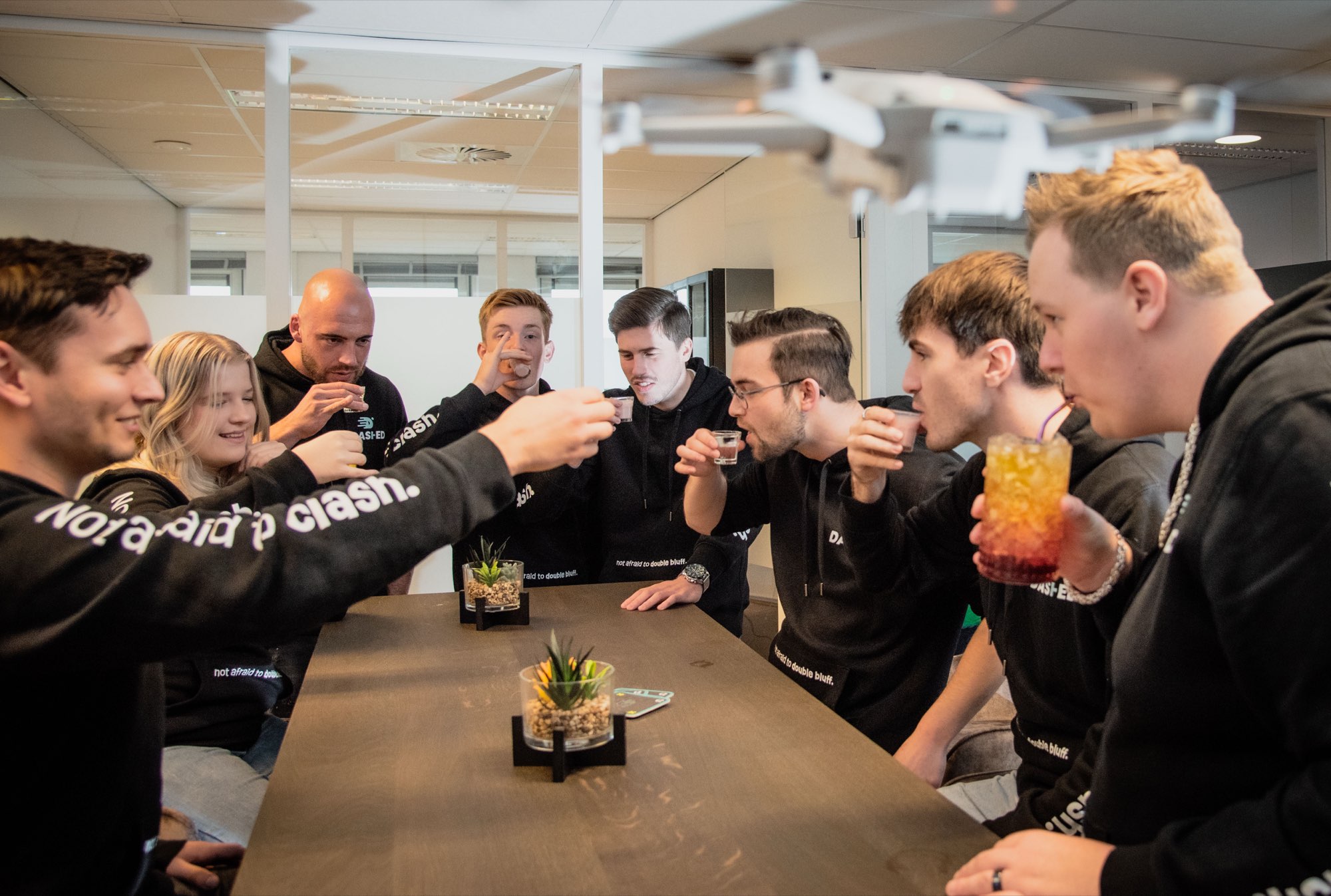 Collega's proosten met een drankje rond de vergadertafel