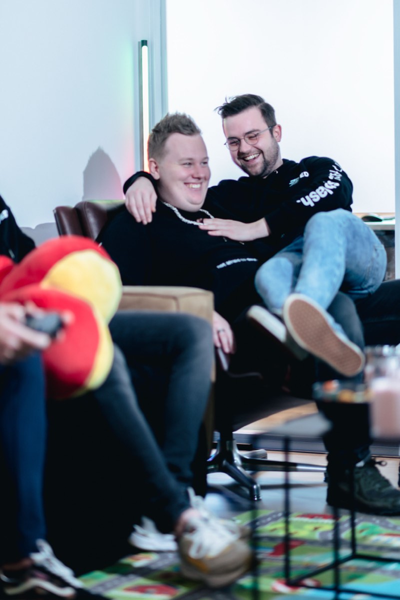 Twee collega's zitten lachend samen op de bank