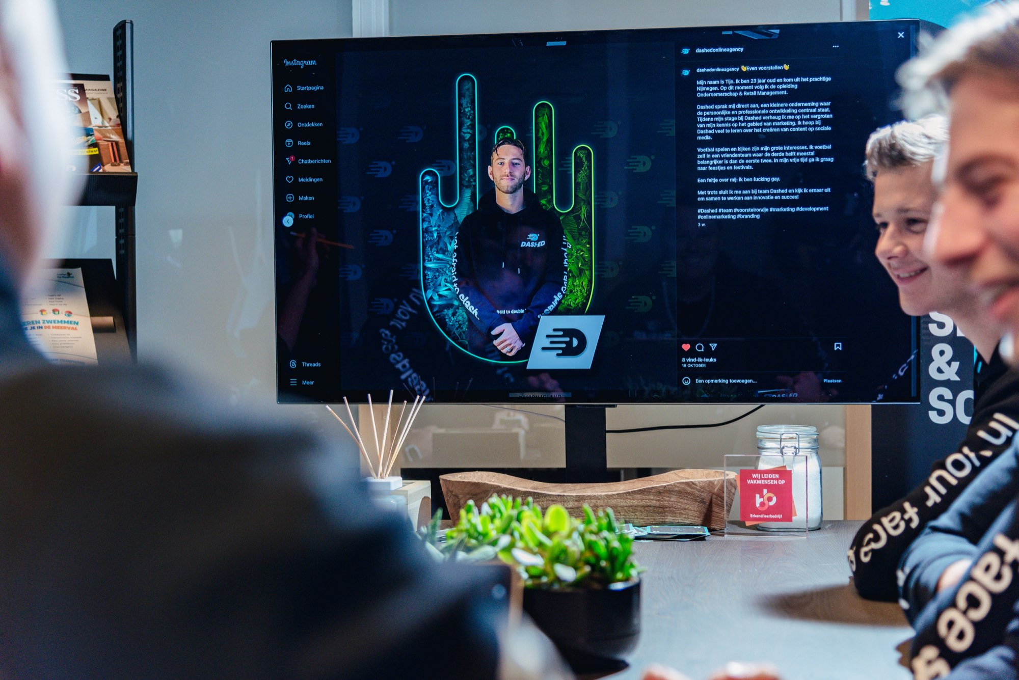 Collega's kijken naar een ontwerp op een groot scherm