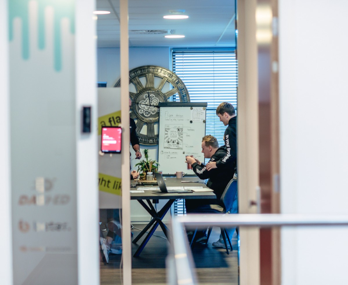 Doorkijk naar een vergaderruimte met whiteboard