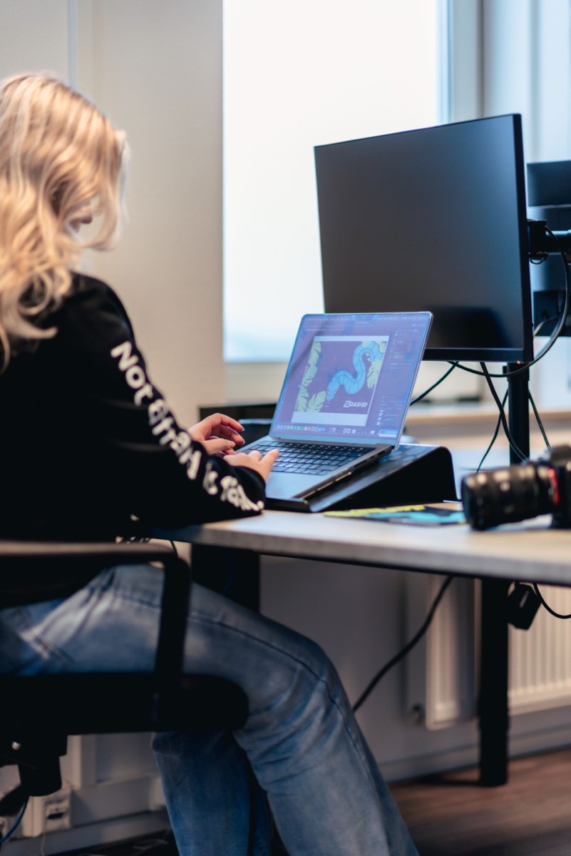 Medewerker aan het werk achter een laptop en monitor