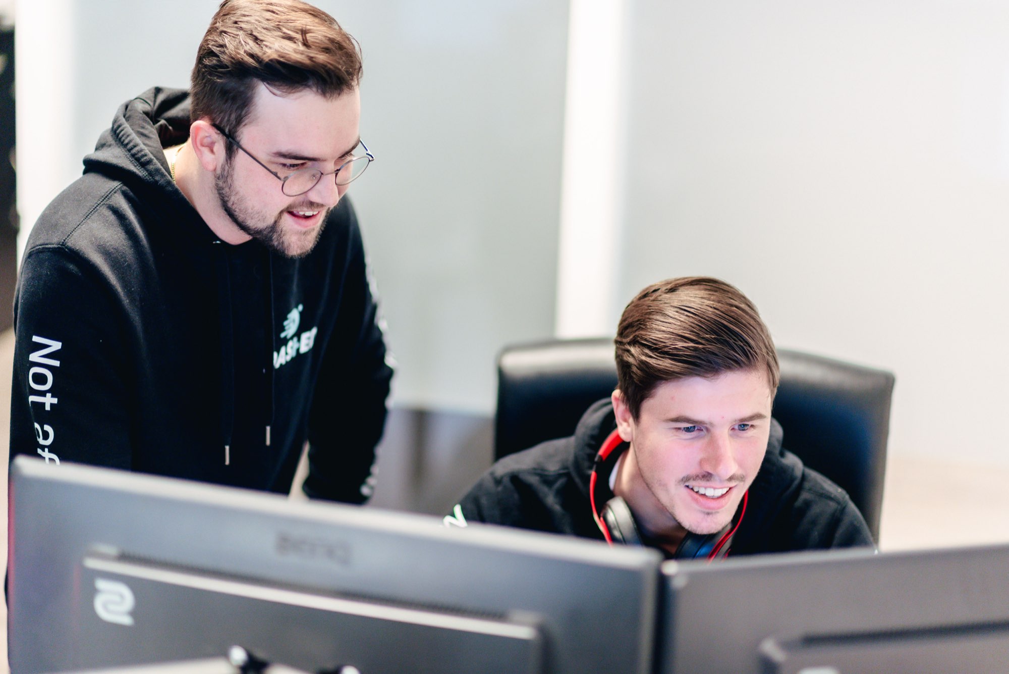 Twee collega's kijken samen naar code op een monitor