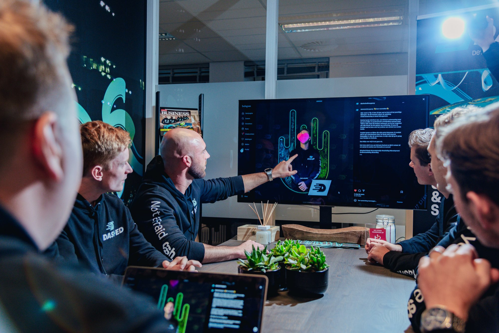 Team bespreekt een ontwerp op het grote scherm in de vergaderruimte