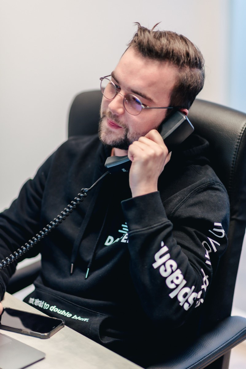 Medewerker voert een telefoongesprek achter zijn werkplek